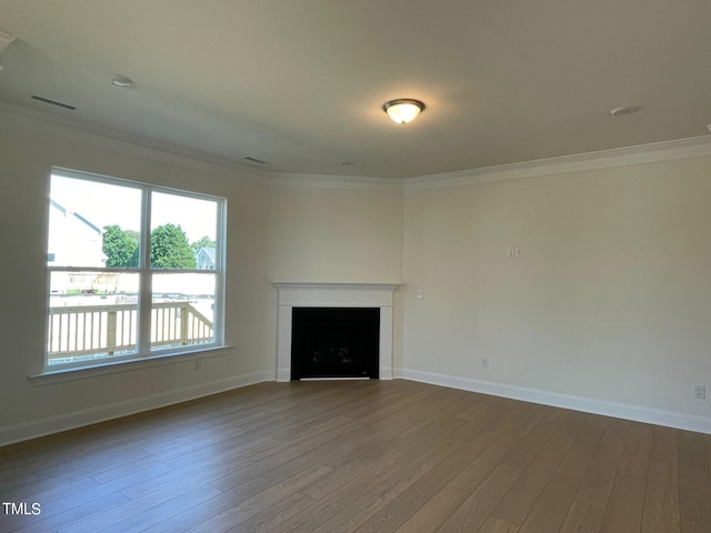 unfurnished living room with crown molding and hardwood / wood-style flooring