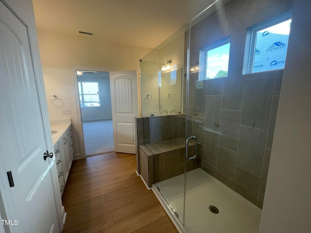 bathroom featuring a shower with shower door, hardwood / wood-style floors, and vanity