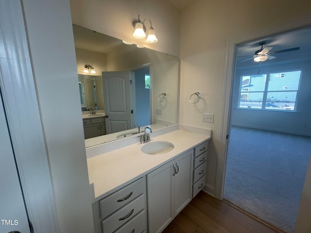 bathroom with ceiling fan, vanity, and wood-type flooring