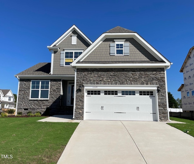 craftsman house with a front yard and a garage