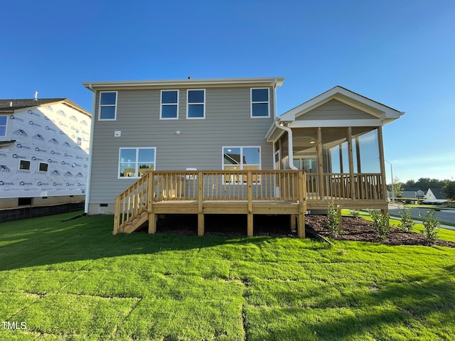 back of property with a yard, a wooden deck, and a sunroom