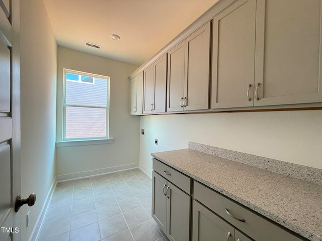 clothes washing area featuring washer hookup, light tile patterned floors, cabinets, and hookup for an electric dryer