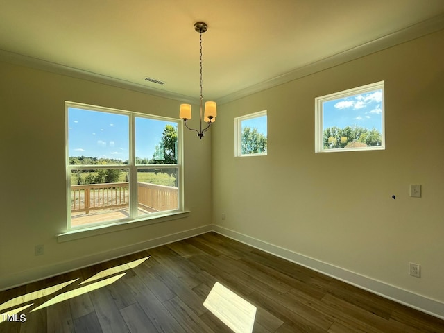 unfurnished dining area with a notable chandelier, plenty of natural light, ornamental molding, and dark wood-type flooring