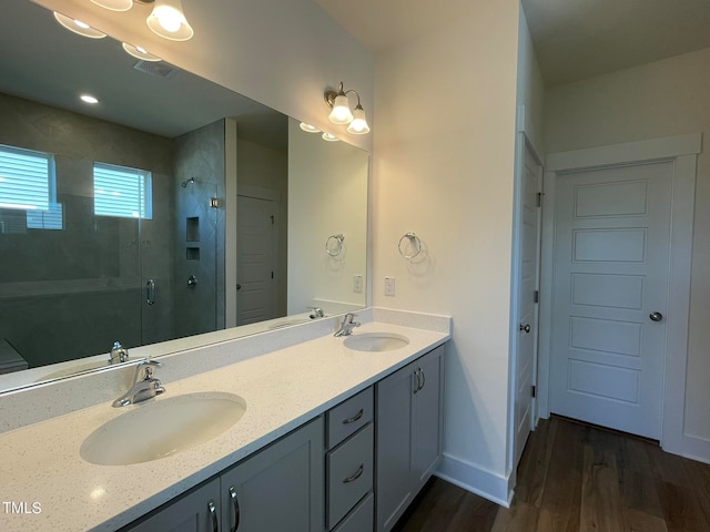 bathroom with hardwood / wood-style floors, vanity, and an enclosed shower