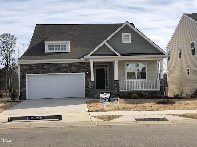 craftsman inspired home with a garage and covered porch