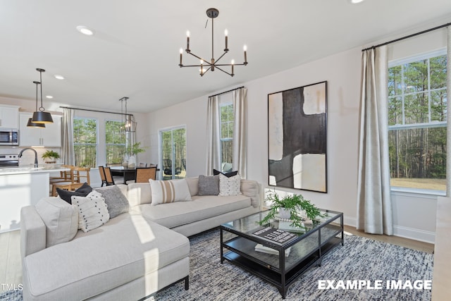 living room featuring plenty of natural light, light hardwood / wood-style floors, and a chandelier