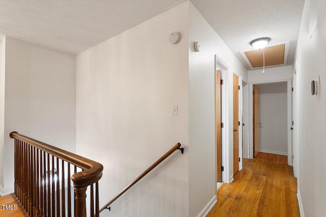 104 Argyle Ct, Garner, NC 27529 - hall with attic access, an upstairs landing, a textured ceiling, and light wood-type flooring