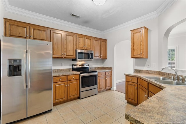 kitchen featuring sink, light tile patterned flooring, ornamental molding, and appliances with stainless steel finishes