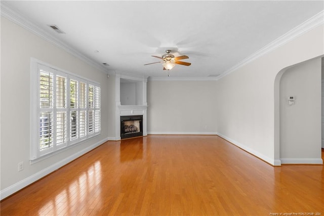 unfurnished living room featuring light hardwood / wood-style floors, ceiling fan, and crown molding