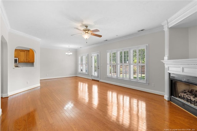 unfurnished living room featuring a wealth of natural light, light hardwood / wood-style floors, and ornamental molding