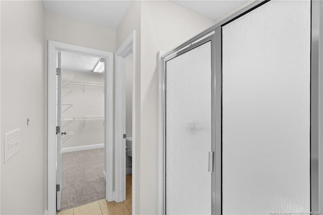 bathroom with tile patterned floors and a shower with door