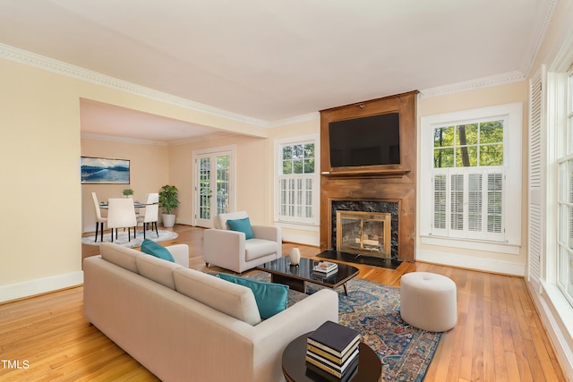 living room with hardwood / wood-style flooring, ornamental molding, plenty of natural light, and a premium fireplace