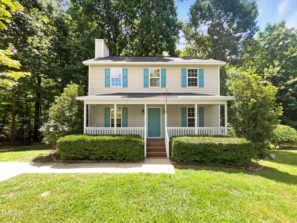 view of front of house featuring covered porch and a front lawn