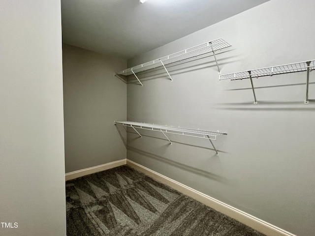 spacious closet with dark carpet