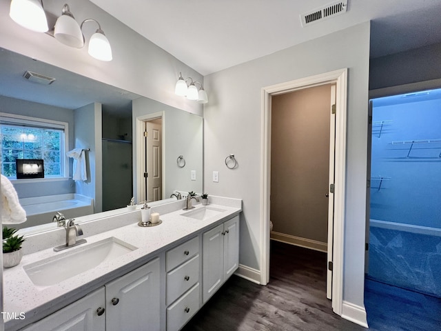 full bathroom with separate shower and tub, toilet, vanity, and hardwood / wood-style flooring