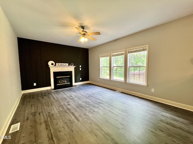 unfurnished living room with ceiling fan and dark wood-type flooring