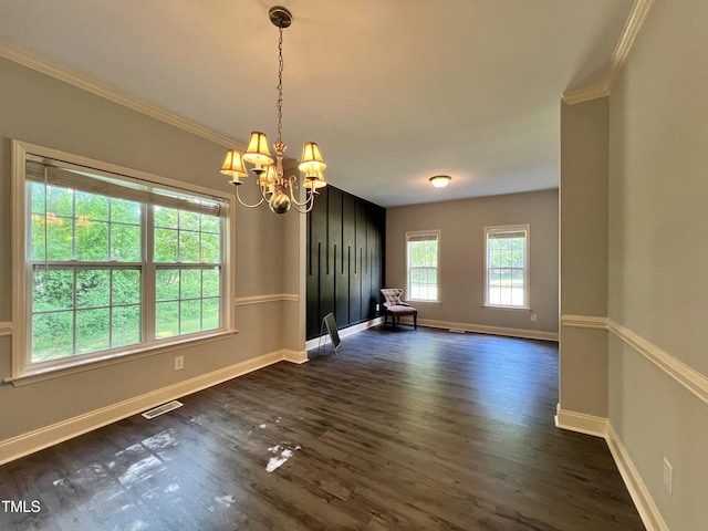 unfurnished dining area featuring dark hardwood / wood-style flooring, an inviting chandelier, and crown molding