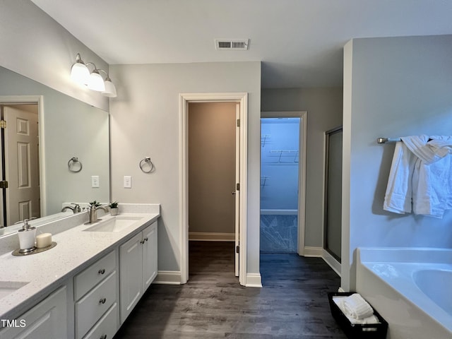 bathroom featuring vanity, wood-type flooring, and shower with separate bathtub