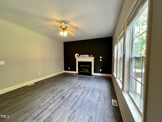 unfurnished living room featuring ceiling fan and dark hardwood / wood-style flooring