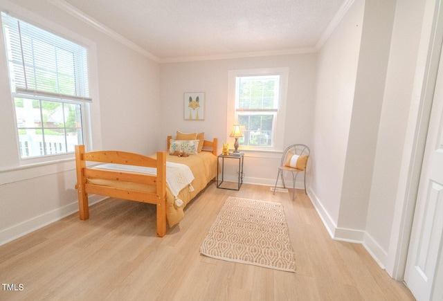 bedroom with multiple windows, crown molding, and light hardwood / wood-style flooring