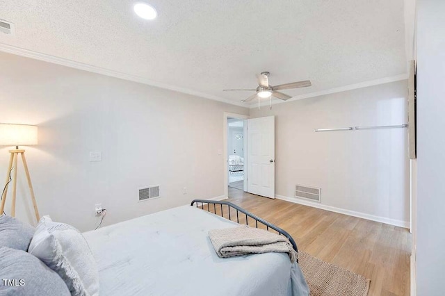 bedroom with ceiling fan, ornamental molding, a textured ceiling, and light hardwood / wood-style flooring