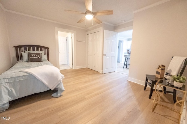 bedroom with crown molding, ceiling fan, light wood-type flooring, and a closet