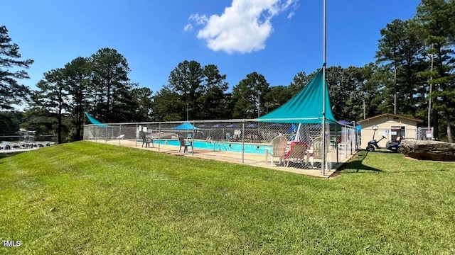 view of swimming pool with a lawn and a storage unit