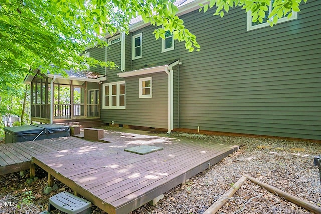 deck with a sunroom and a covered hot tub