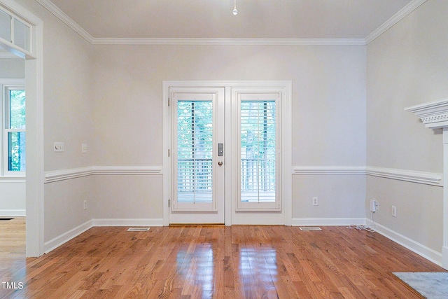 doorway featuring crown molding, light hardwood / wood-style flooring, a wealth of natural light, and french doors