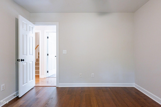 spare room with dark wood-type flooring