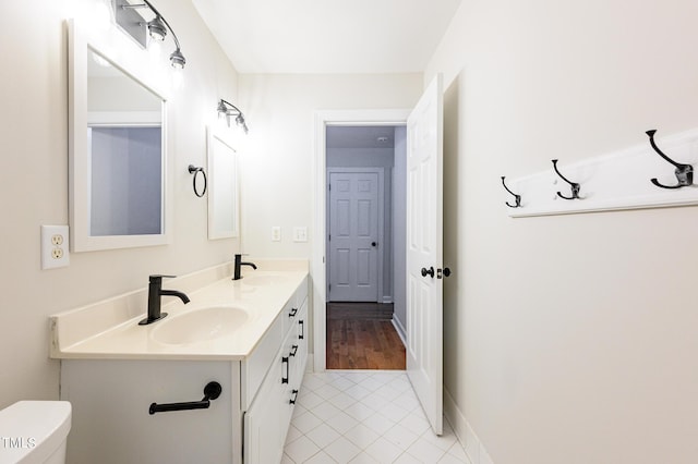 bathroom with toilet, vanity, and tile patterned flooring