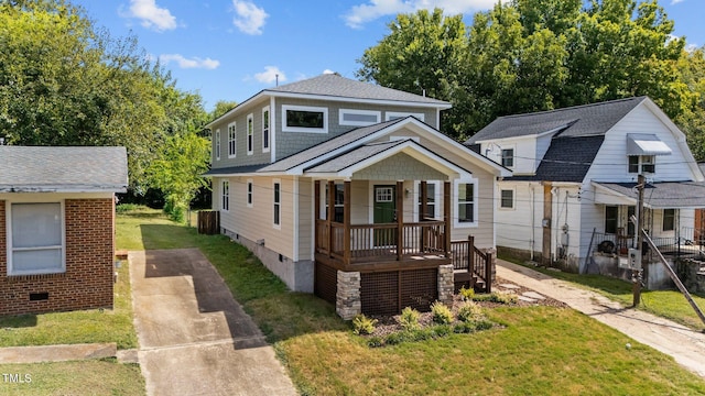 bungalow with covered porch and a front yard