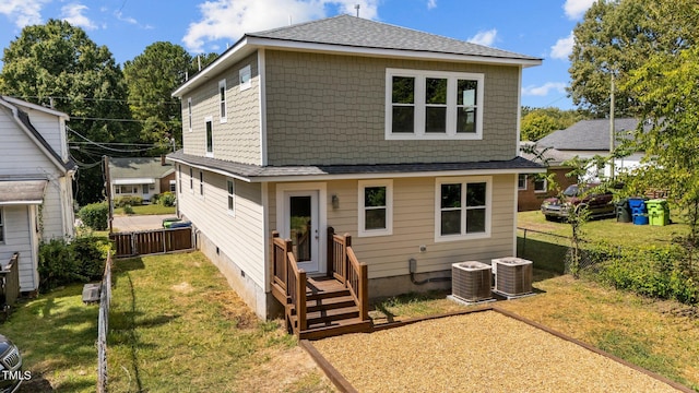 rear view of house with a lawn and central air condition unit