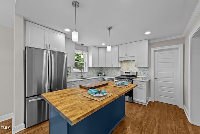 kitchen featuring stainless steel appliances, white cabinets, a center island, and hardwood / wood-style flooring