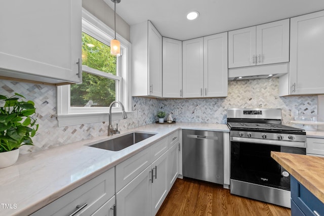 kitchen featuring white cabinetry, backsplash, dark hardwood / wood-style flooring, stainless steel appliances, and sink