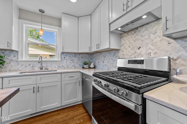 kitchen featuring sink, white cabinets, stainless steel range with gas stovetop, decorative backsplash, and dark hardwood / wood-style flooring