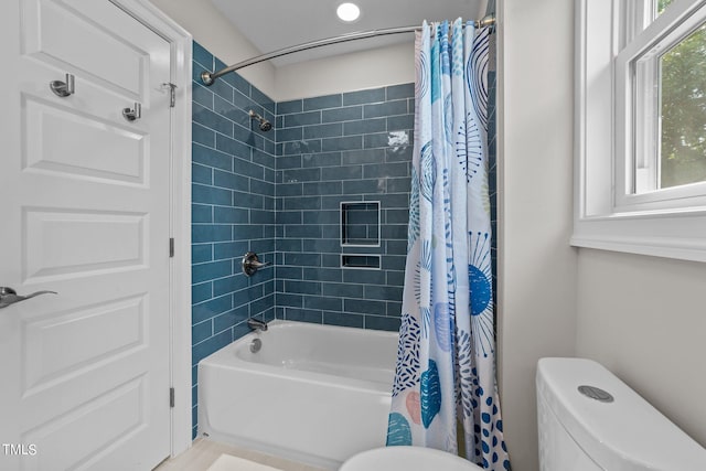 bathroom featuring shower / tub combo and toilet