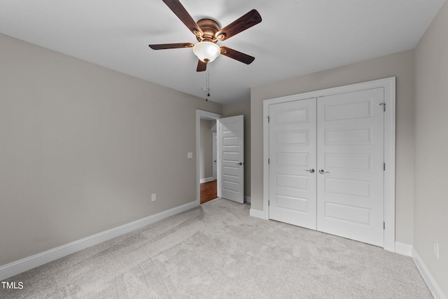 unfurnished bedroom with ceiling fan, a closet, and light carpet