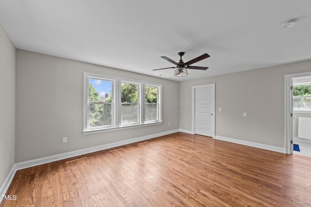 unfurnished room with ceiling fan, hardwood / wood-style floors, and a healthy amount of sunlight