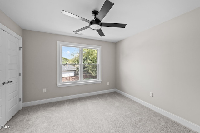 carpeted spare room featuring ceiling fan