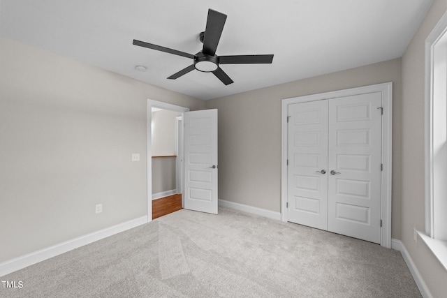 unfurnished bedroom with light carpet, a closet, and ceiling fan