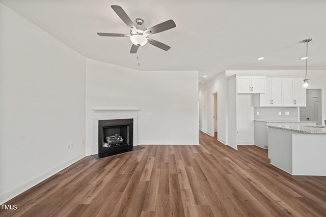 unfurnished living room with hardwood / wood-style flooring and ceiling fan