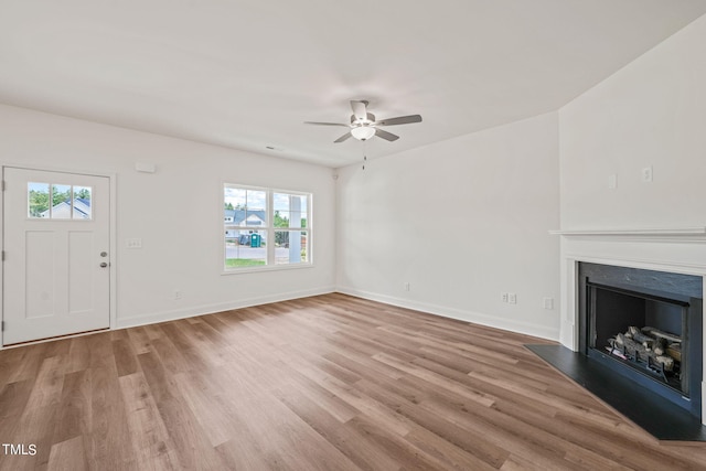 unfurnished living room with light wood-type flooring, ceiling fan, and a healthy amount of sunlight