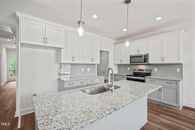 kitchen with decorative light fixtures, appliances with stainless steel finishes, sink, and white cabinetry