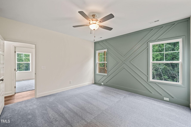 empty room with ceiling fan and carpet