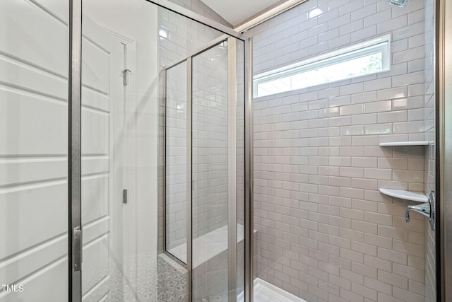 bathroom with a shower with door