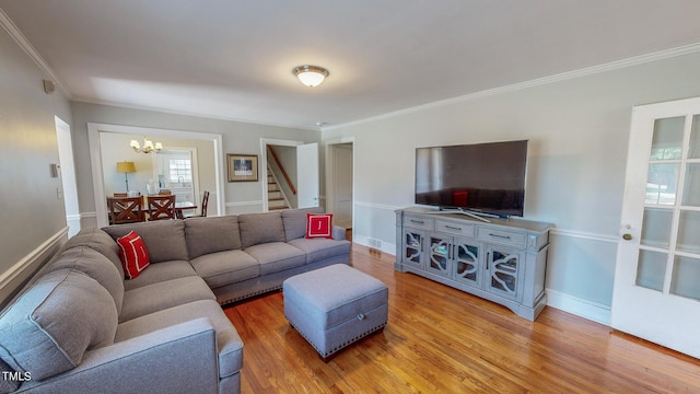 living room with a notable chandelier, crown molding, and wood-type flooring