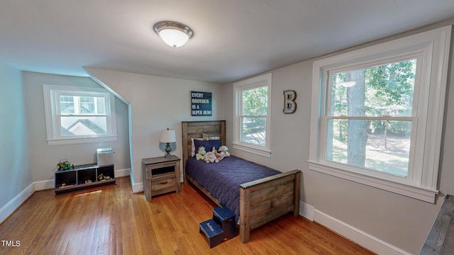 bedroom with hardwood / wood-style floors and multiple windows