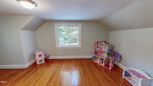 game room with light hardwood / wood-style floors and vaulted ceiling