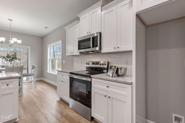 3097 Banks School Rd, Kinston, NC 28504 - kitchen with stainless steel appliances, tasteful backsplash, baseboards, light wood-style floors, and a chandelier
